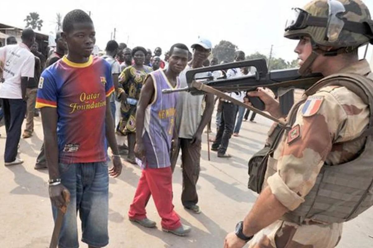 جندي فرنسي يوجه سلاحه نحو متظاهر إفريقي